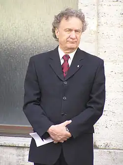 Markuš in a suit and tie looking to the right of the picture