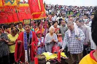 A taoist priest wearing a modern-day taoist's daopao (depicted as a red overcoat), 2017.