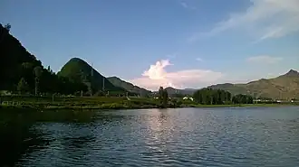 The right side with lush forest is Ji'an, China, and on the left is Manpo, North Korea, which can be identified by bare hills, as forests were all chopped for firewoods