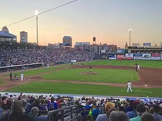 A green baseball field at dusk