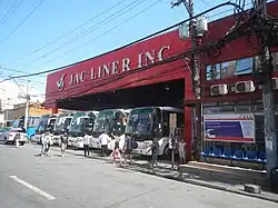 A bus terminal along the avenue, painted red
