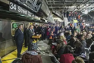 People speaking at a ceremonial speech at the 34th Street station on December 20, 2013