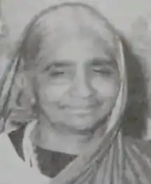 Older South Asian woman, smiling.