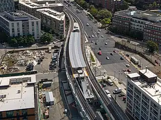 Aerial view of an under-construction rapid transit station in an urban square