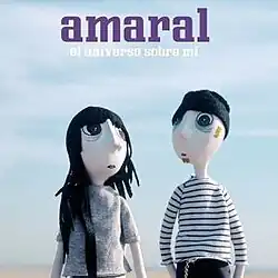The band Amaral is represented by two dolls standing in front of a landscape. In the centre, at the top, the name of the band and the name of the song is written.