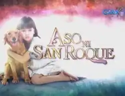 An image of Mona Louise Rey hugging a dog. The series title is displayed on the center of the image. The logo of GMA Network is displayed on the upper right side of the image.