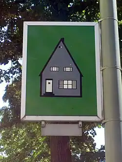 Green sign depicting a gray house
