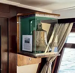 Ship’s bell in display case in ship’s bar.