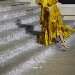 Cover art for "Hold Up": Beyoncé in a yellow dress, walking down a flooded staircase