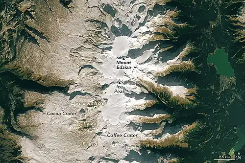 An overhead view of a barren, rocky plateau with a glaciated mountain in the middle.
