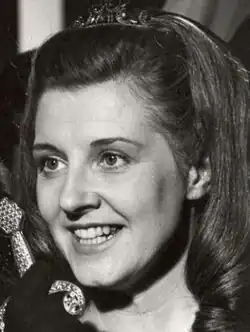 Three-quarter profile Press shot of a smiling young woman with long blonde hair, in Queen of the Night stage costume