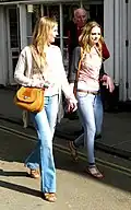 Image 140Two women wearing flared trousers, jeggings and oversized cardigans, 2011. (from 2010s in fashion)