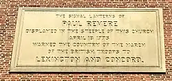 Photo of inscription on the side of the church which reads "The signal lanterns of Paul Revere displayed in the steeple of this church, April 18, 1775, warned the country of the march of the British Troops to Lexington and Concord."