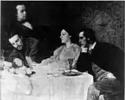 Portrait of Joanna Mary Boyce and three family members, seated around a table.
