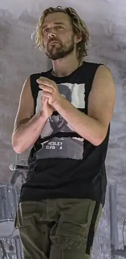 Van den Berg standing with his hands clasped