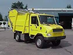 A small yellow garbage truck