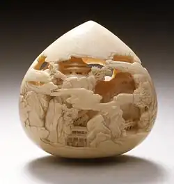Jewel of Wisdom carved with mountain pavilions. Stained ivory