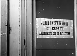 Photograph of a sign on a door reading "Jews Undesirable"