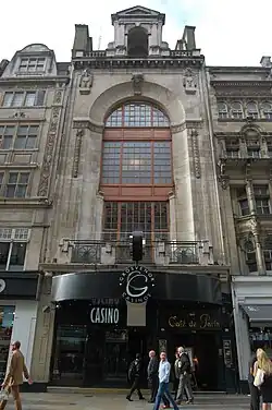 Front of the Cafe de Paris, a six-storey building dominated by a glass frontage in the upper storeys.