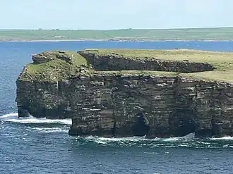 Grey Head, the northern tip of the Calf. Sea caves, and the beginning of an arch can be seen in the cliff.