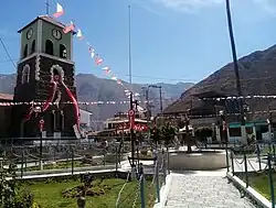 An image of Callahuanca Main Square as seen in 2021 with festive flags and a roundabout