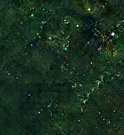 Cassiopeia A infrared echo as seen by unWISE. The observation time in this image ranges from 2015 (red) to 2020 (blue). The infrared echo appears as rainbow colored clouds. North is up.