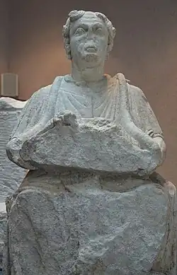 Statue of Cernunnos from Sommerécourt, Haute-Marne. His horns have been broken off. Two horned snakes feed from a bowl in the figure's hands.: no 8 