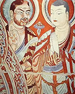 A blue-eyed Central Asian monk teaching an East-Asian monk, Bezeklik, Turfan, eastern Tarim Basin, China, 9th century; the monk on the right is possibly Tocharian,[152] although more likely Sogdian.[153][154]