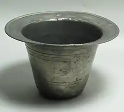 A cylindrical metal container with a brim, much like an upside-down hat