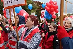 a crowd holding banners and balloons