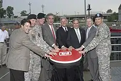A group of military and civilians pressing an oversized red button