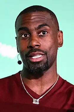 DeRay Mckesson speaking on a teal background