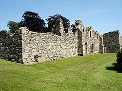 Ruined castle stone walls including doorways, windows and two buttresses