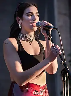 Colour photograph of Dua Lipa performing in 2017