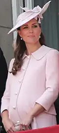 A photograph of Catherine wearing a pale pink coat dress and a fascinator of the same colour.