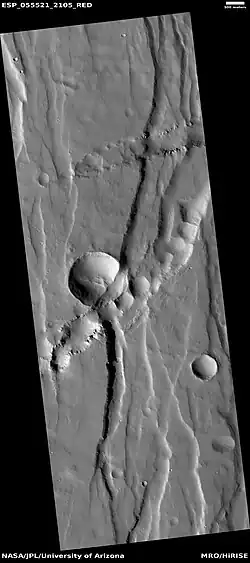 Troughs (Fossae), as seen by HiRISE under HiWish program. Trough seems to have cut away part of a crater.