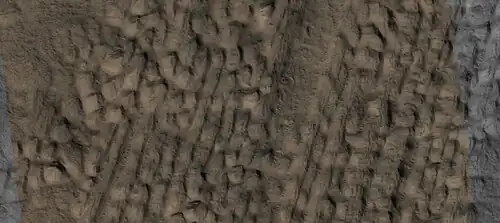 Close view of lineated valley fill (LVF) in valley, as seen by HiRISE under HiWish program. Linear valley flow is ice covered by debris. Picture is about 1 km wide. Lineated valley fill is generally considered to be and example of a glacier, as it involves the movement of ice.