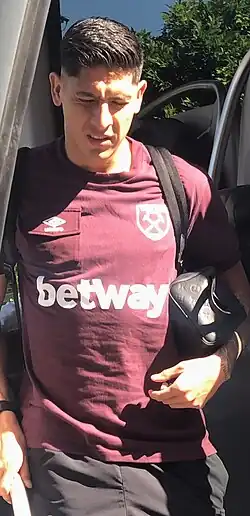Picture of Edson Alvarez getting of the West Ham United team bus wearing the classic West Ham colours of purple and light blue.
