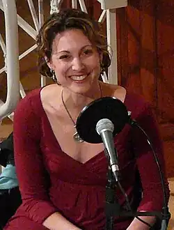 Bazelon sits at a microphone