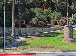 Picture of the entrance to Elysian Park with path, stone wall, and sidewalk