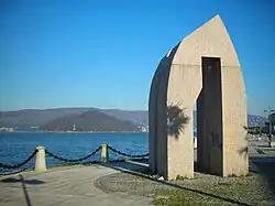 Sculpture on the harbour promenade with the island of Tambo in the background.