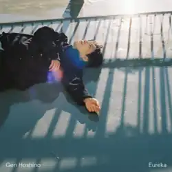 The cover art to "Eureka". It features Hoshino laying on a pavement, covered in sunlight and the shadow of a handrail. Hoshino's name and the song's title are found in the bottom left and right corners, respectively.