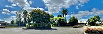 Farnborough Drive roundabout, Thornton - the suburb is flat, single storey, with wide, tree-lined roads
