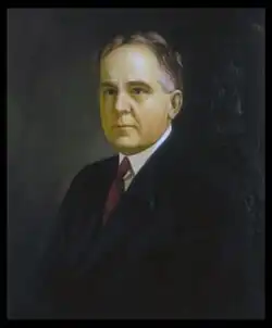A color portrait of a man in his fifties wearing a suit
