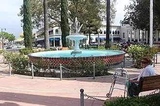 Historic fountain surrounded by trees in the center of a circular plaza