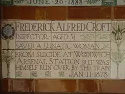 A tablet formed of five tiles of varying sizes, bordered by yellow and blue flowers in an art nouveau style