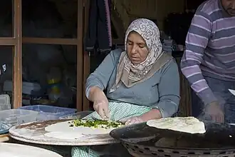 Gözleme, a filled bread, being baked on a sac