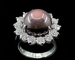 An 11.26 ct. deep purple quahog pearl, diamond, and platinum ring