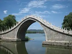 A masonry moon bridge showing the buttressing approach ramps that take the horizontal thrust of the arch