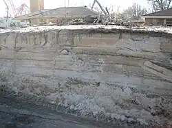 New Orleans after Hurricane Katrina: Unlithified sediment layers laid down in historic times. This cut was an attempt to find bedrock near a residential street near the lower breach of the London Avenue Canal after restoring the levees which has been plowed/excavated clear by the Army Corps of Engineers, showing a nascent stratigraphy in the large deposits of silt deposited by flooding in recent earth history.